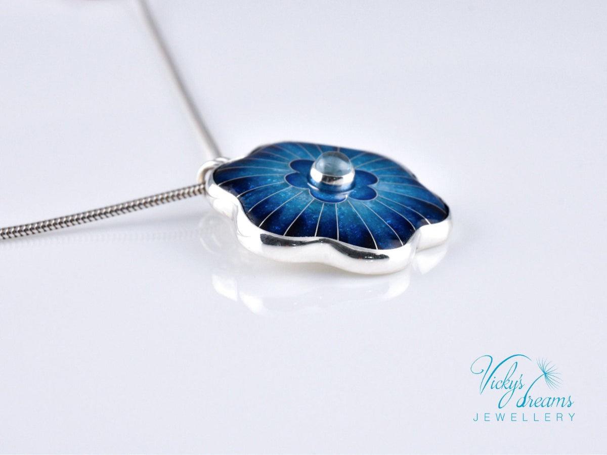 Cloisonné blue flower pendant with natural sky blue topaz set in sterling silver.