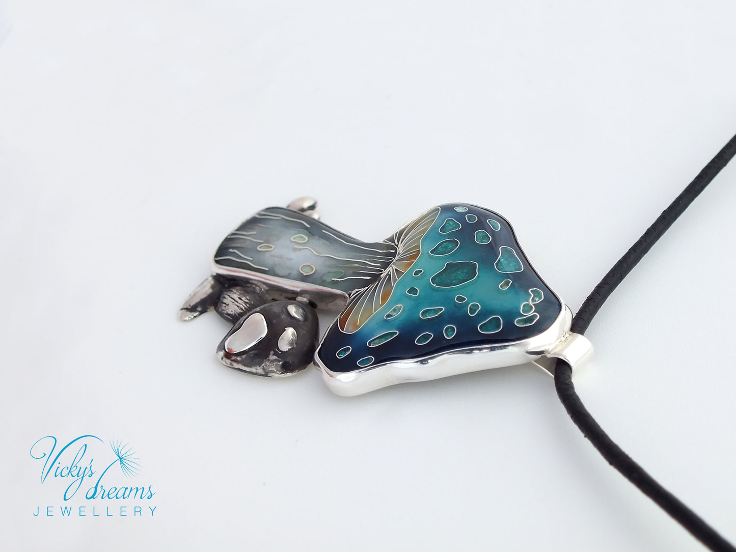 Jewelry pendant with blue and silver design on a white background