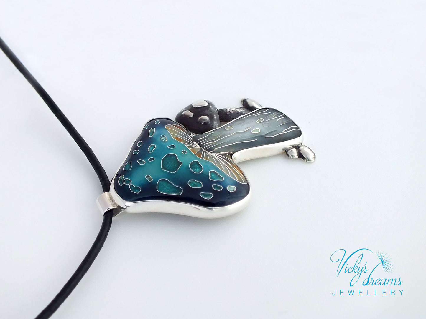 Butterfly-shaped pendant with blue and green pattern on a white background