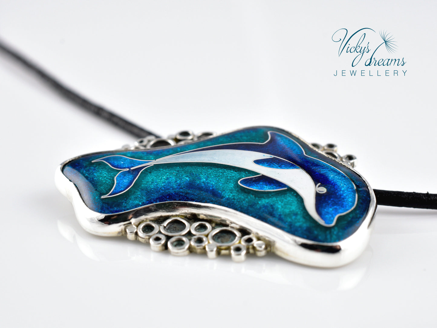 Jewelry pendant with dolphins on a white background, branded 'Vicky's Dreams Jewellery'.