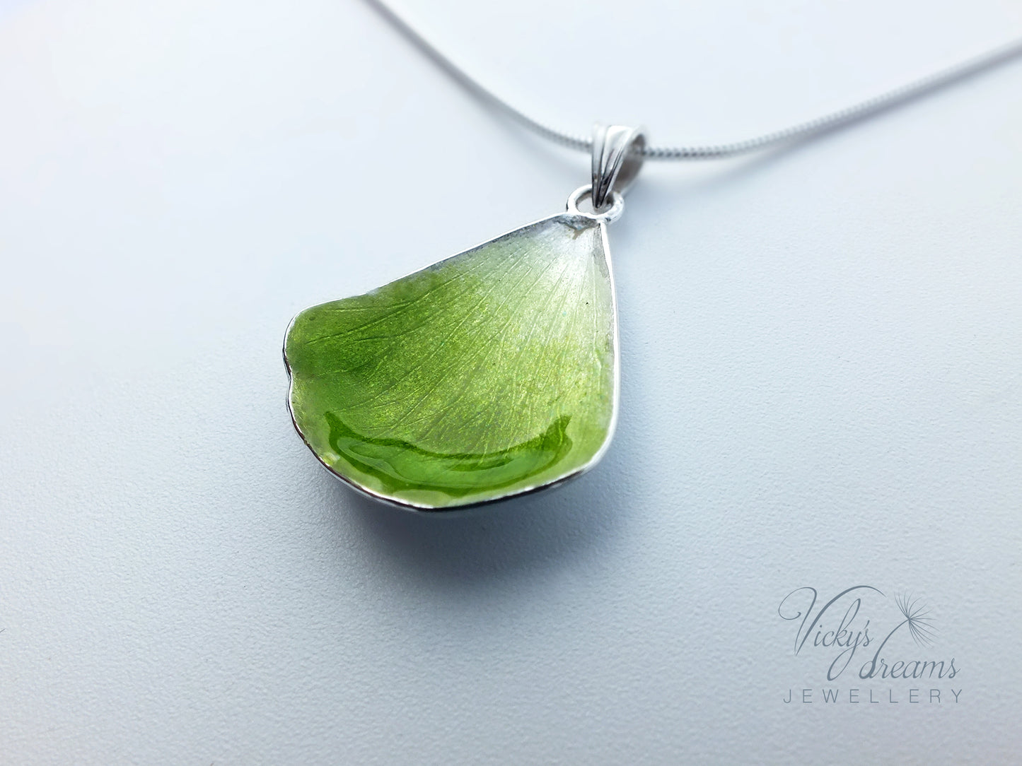 Green flower petal pendant worn on sterling silver necklace
