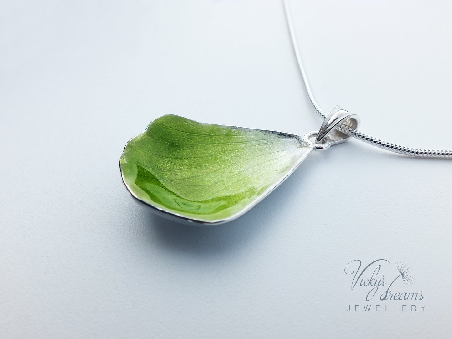 Green flower petal pendant worn on sterling silver necklace