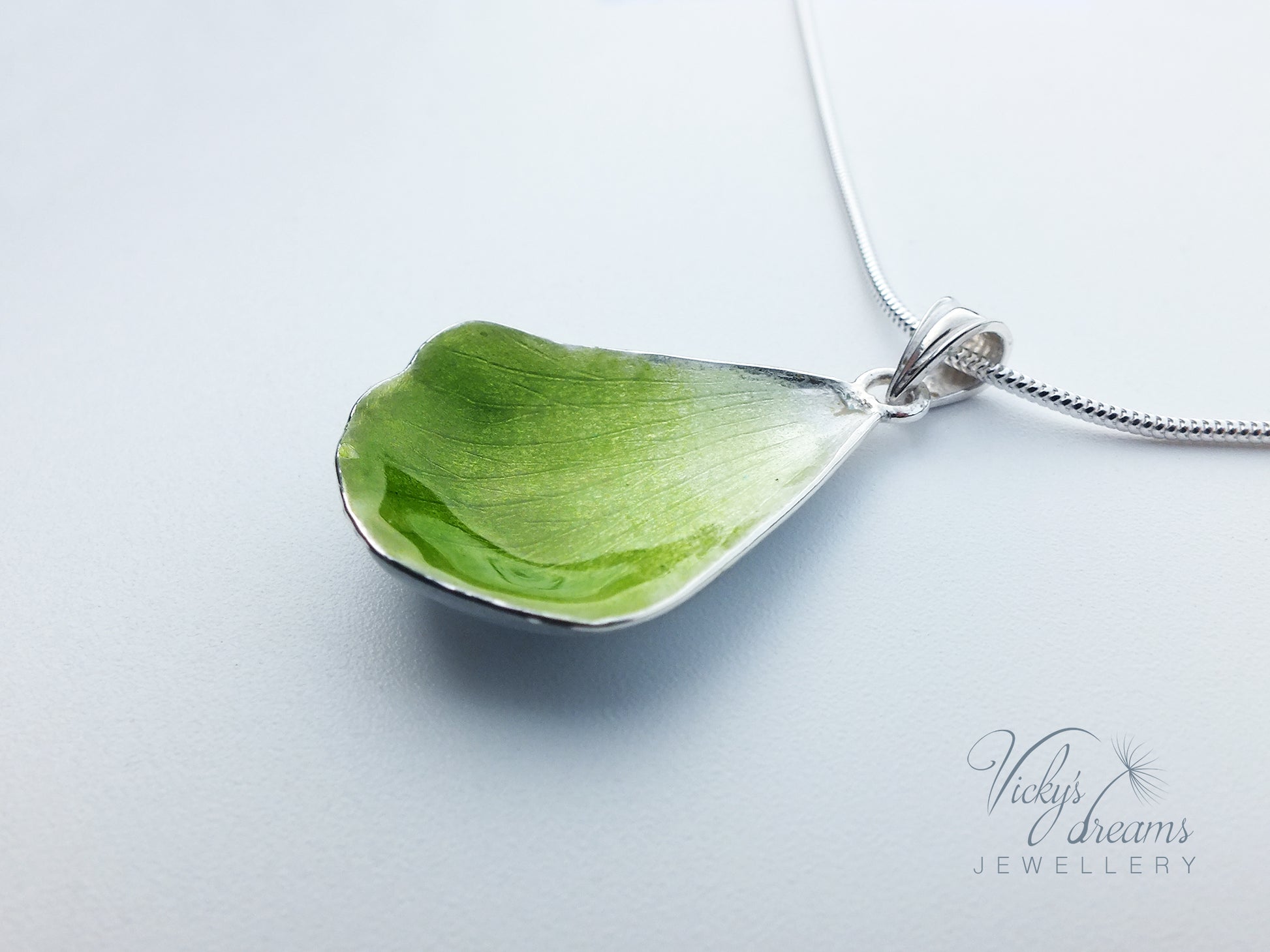 Green flower petal pendant worn on sterling silver necklace