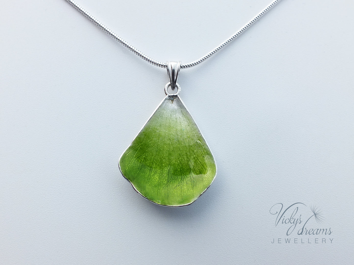 Green flower petal pendant worn on sterling silver necklace