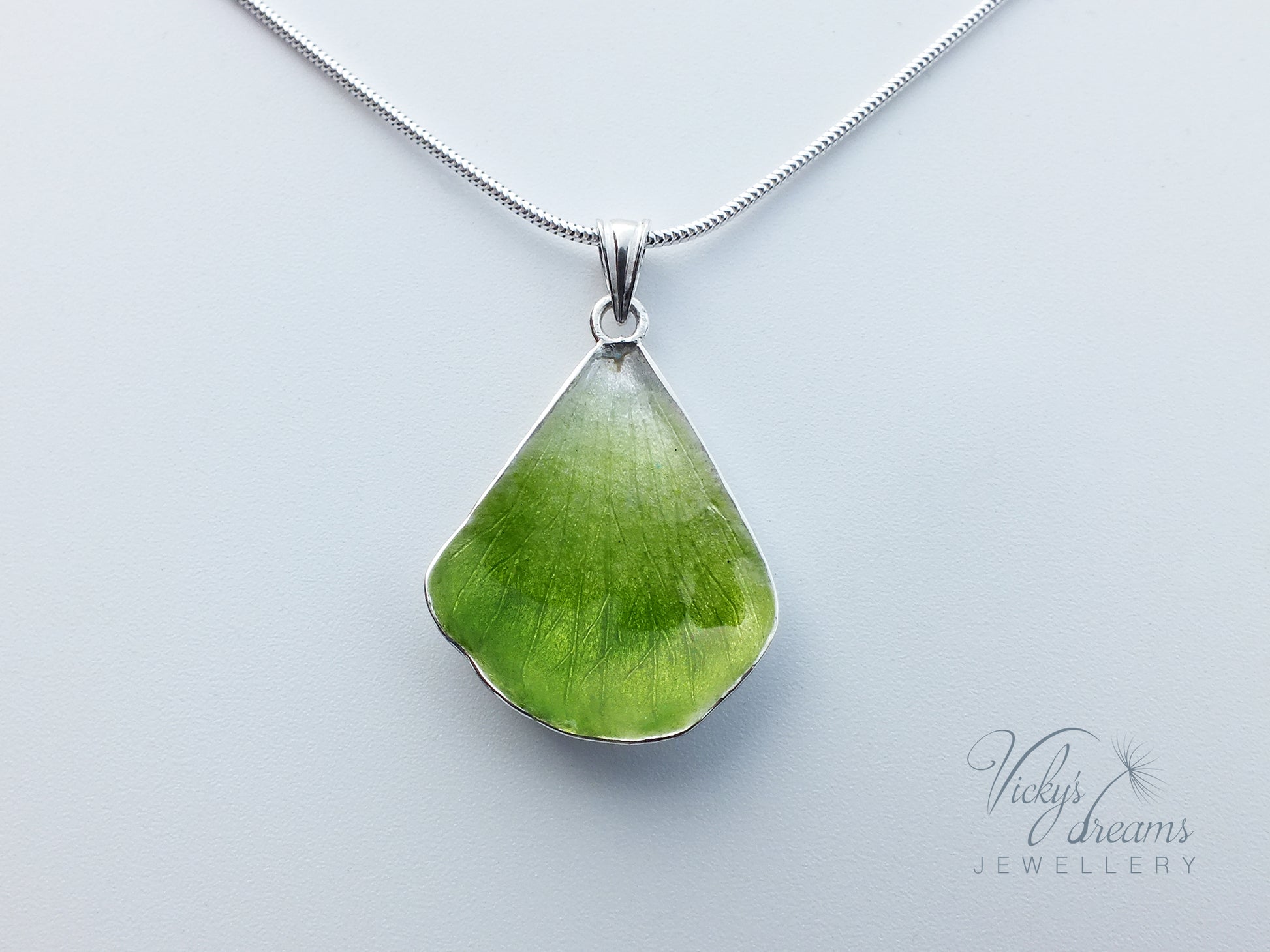 Green flower petal pendant worn on sterling silver necklace