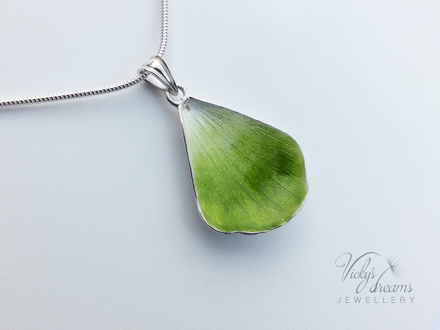 Green flower petal pendant worn on sterling silver necklace