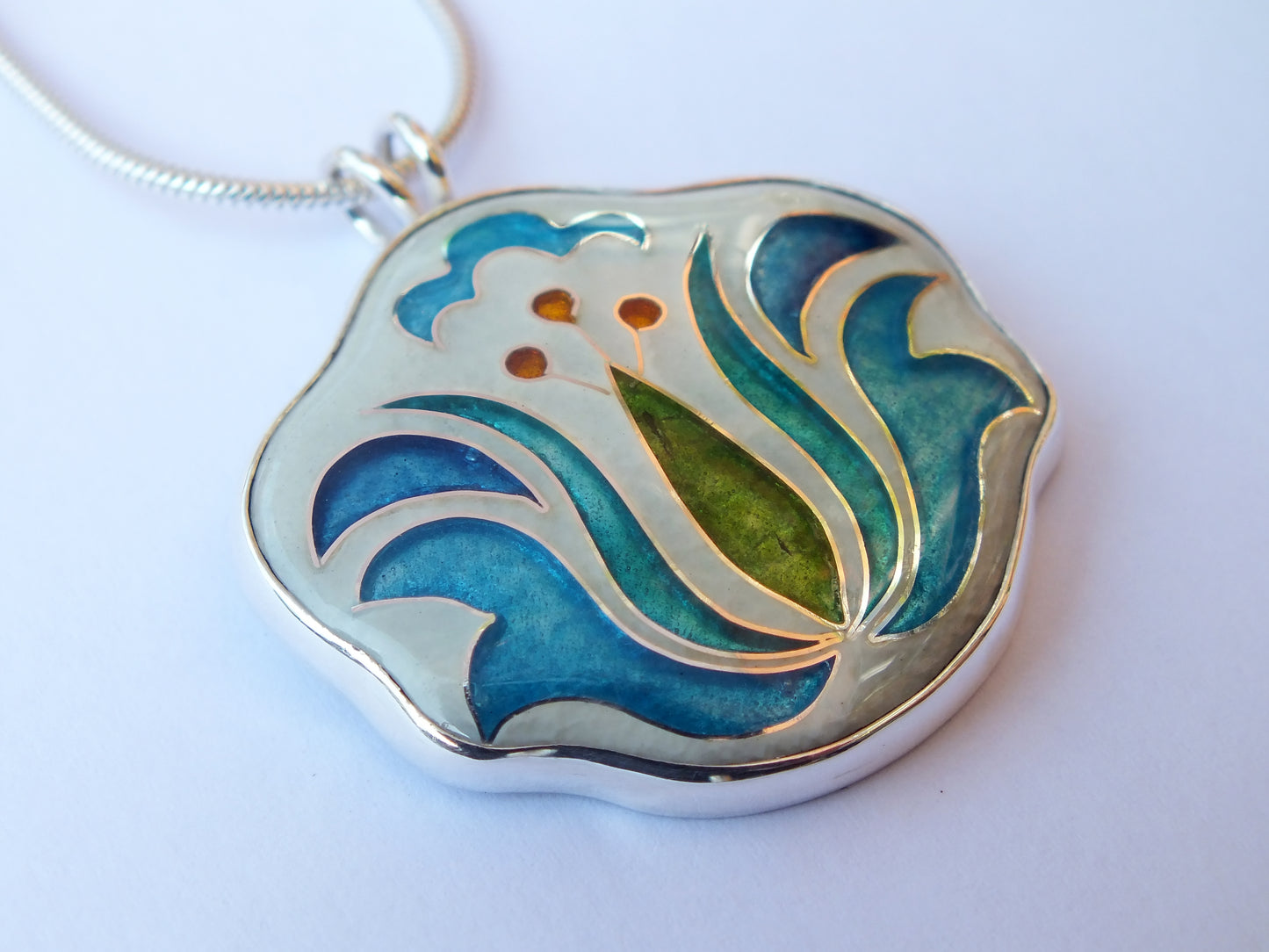 Decorative pendant with blue and green design on a white background