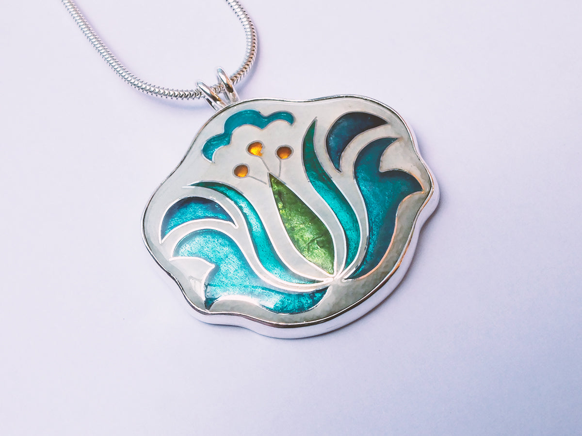 Decorative pendant with blue and green design on a light gray background