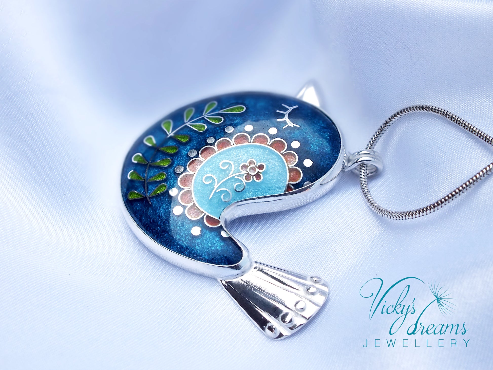 Decorative pendant with floral design on a blue background, featuring 'Vicky's Dreams Jewellery' logo.