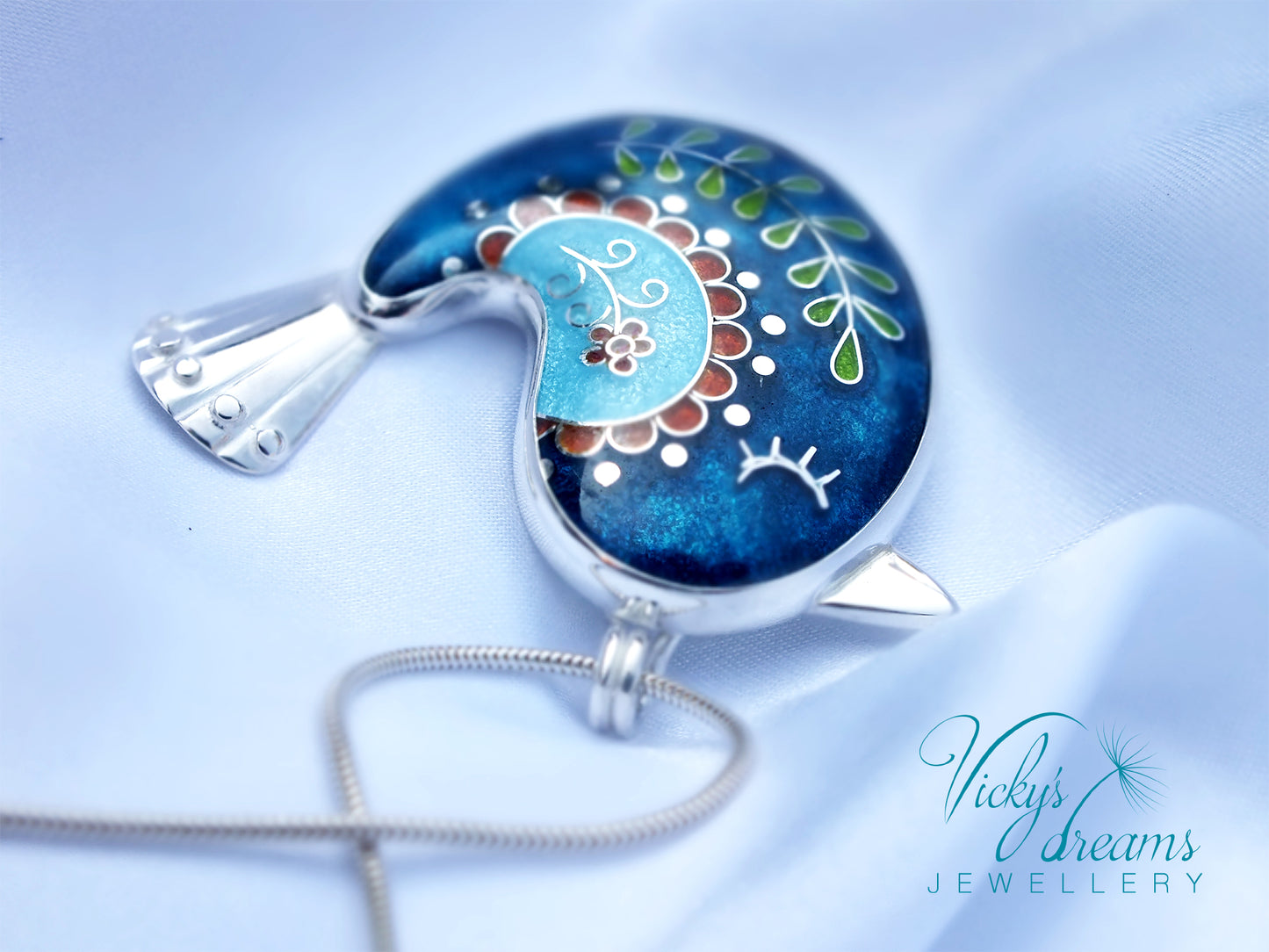 Decorative pendant with floral design on a blue background, featuring 'Vicky's Dreams Jewellery' logo.