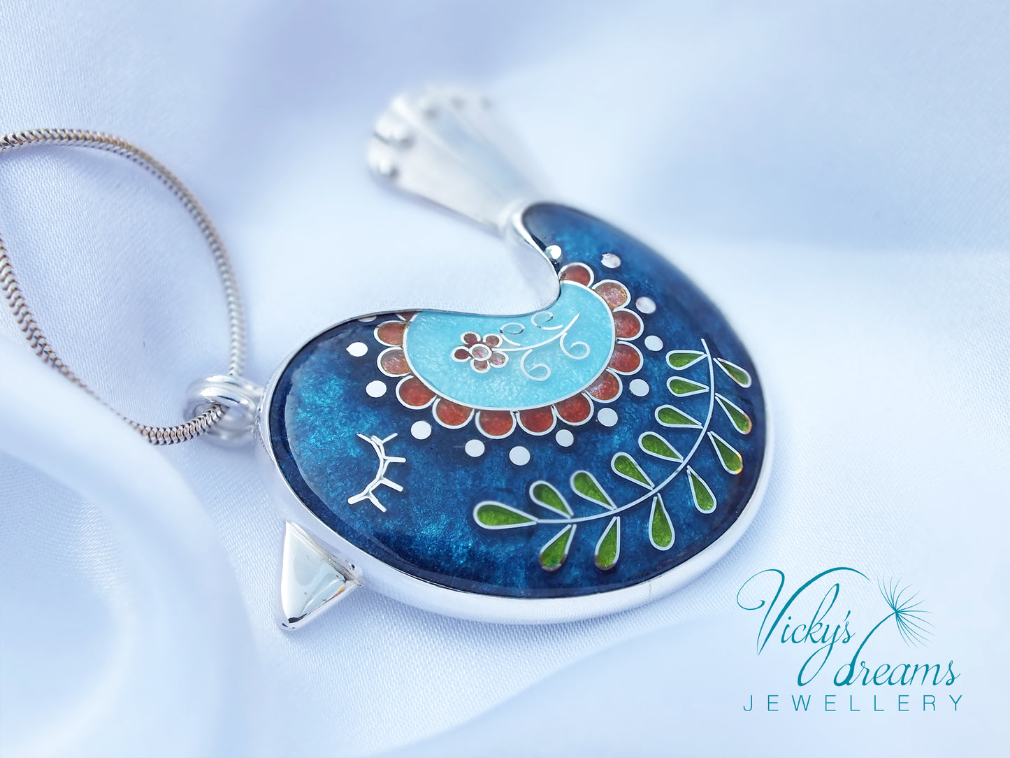 Decorative pendant with floral design on a blue background, branded 'Vicky's Dreams Jewellery'.