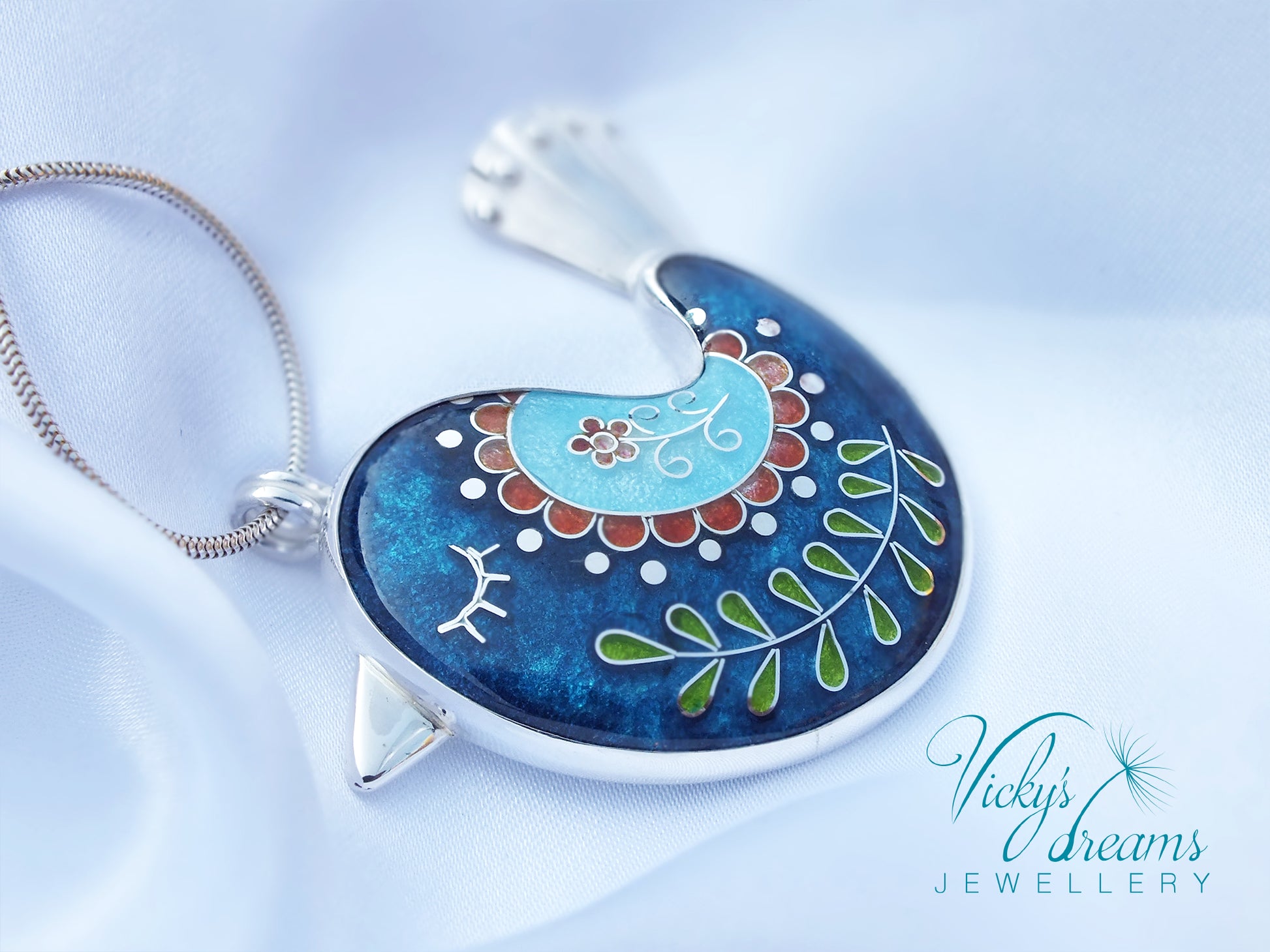 Decorative pendant with floral design on a blue background, branded 'Vicky's Dreams Jewellery'.