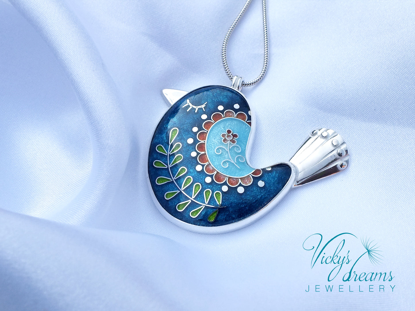 Decorative pendant on a chain with intricate design, featuring the brand 'Vicky's Dreams Jewellery'.