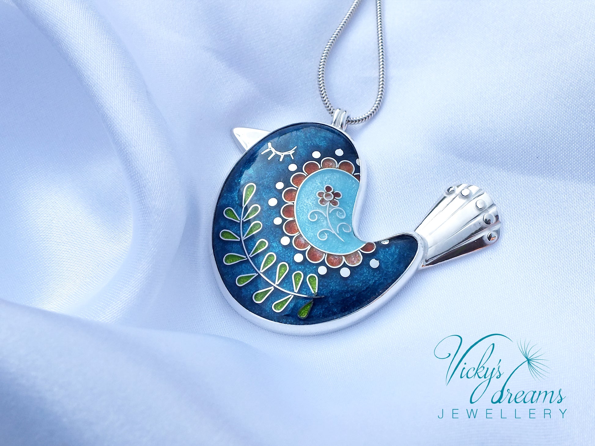 Decorative pendant on a chain with intricate design, featuring the brand 'Vicky's Dreams Jewellery'.