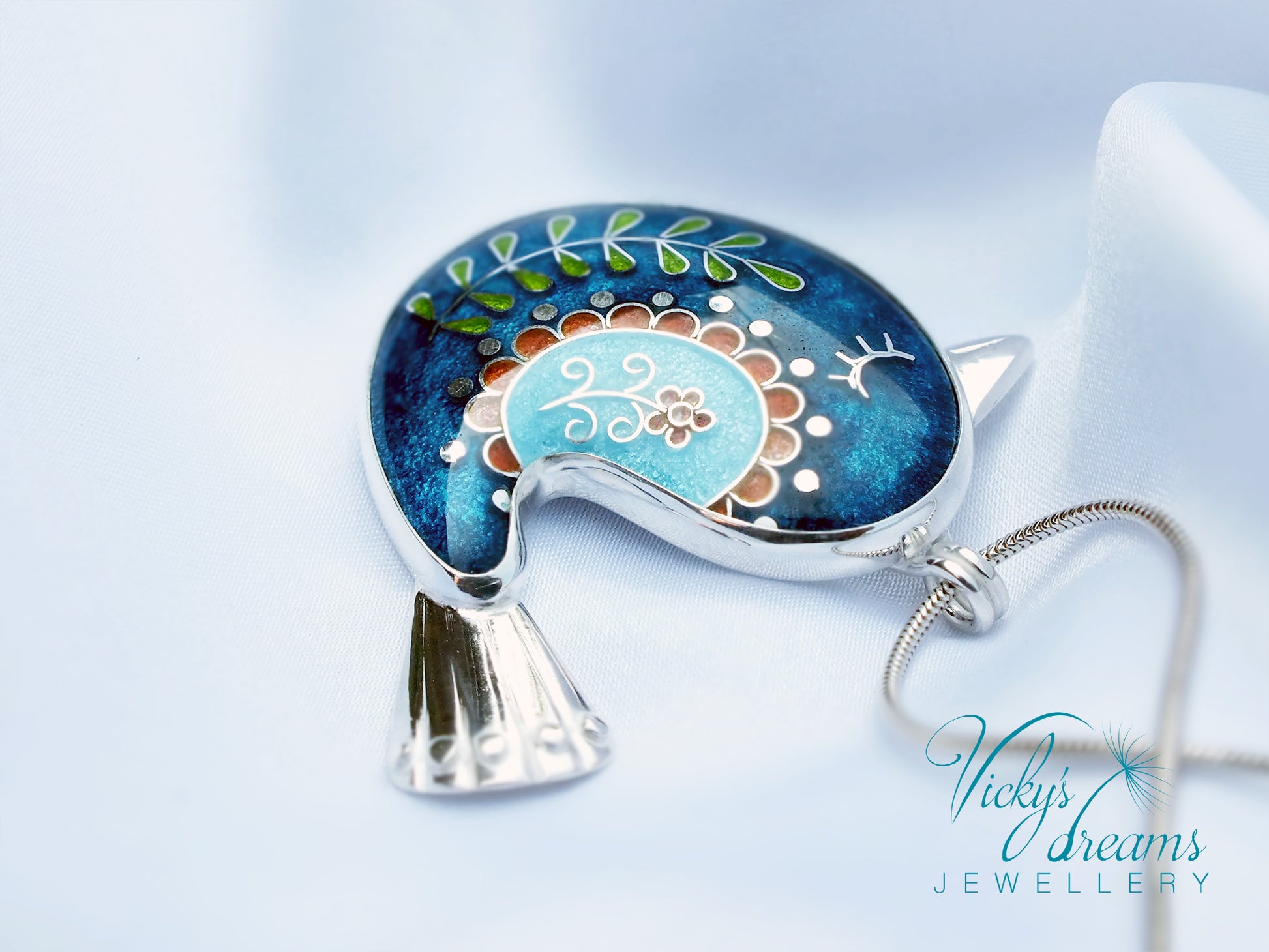 Decorative pendant with floral design on a blue background, featuring 'Vicky's Dreams Jewellery' logo.