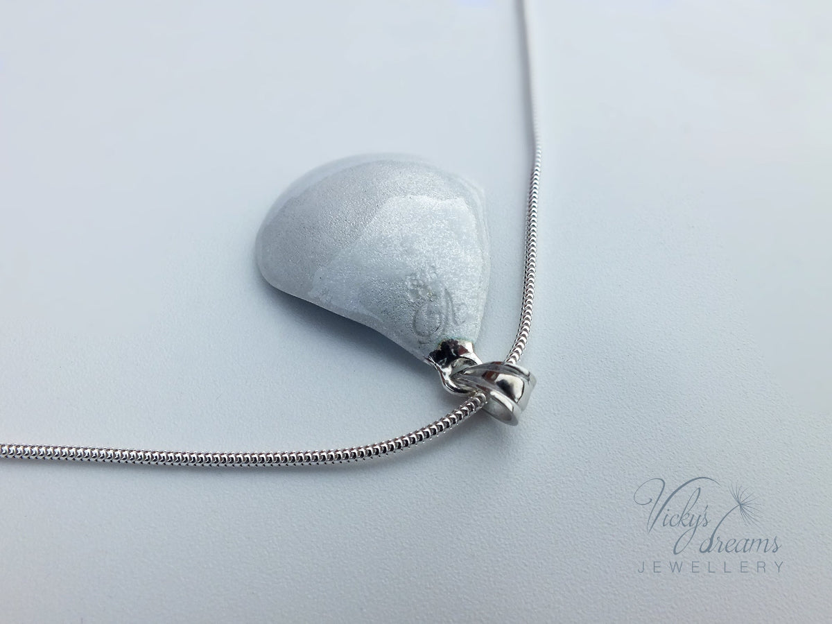 Pink flower petal pendant worn on sterling silver necklace