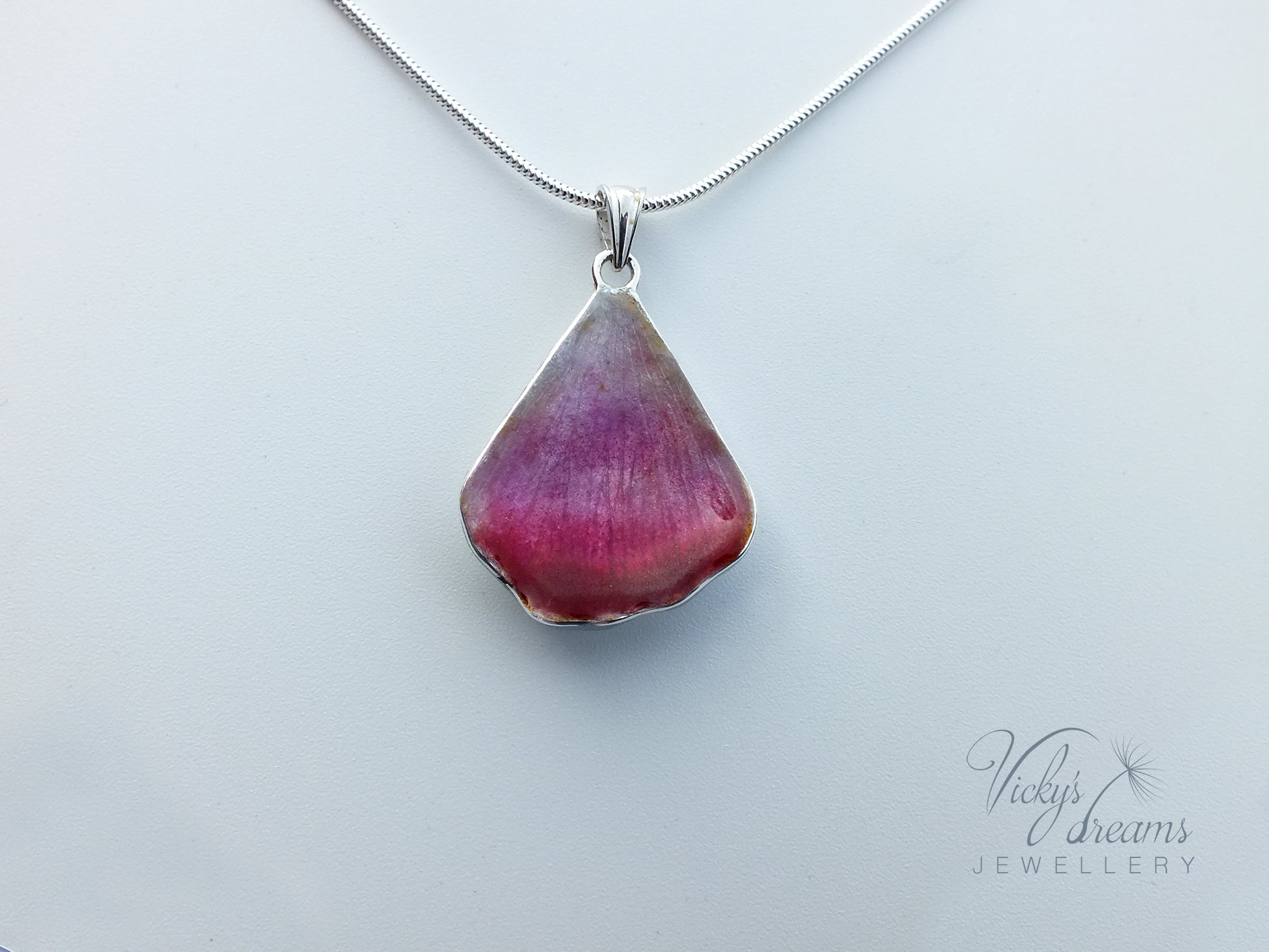Pink flower petal pendant worn on sterling silver necklace