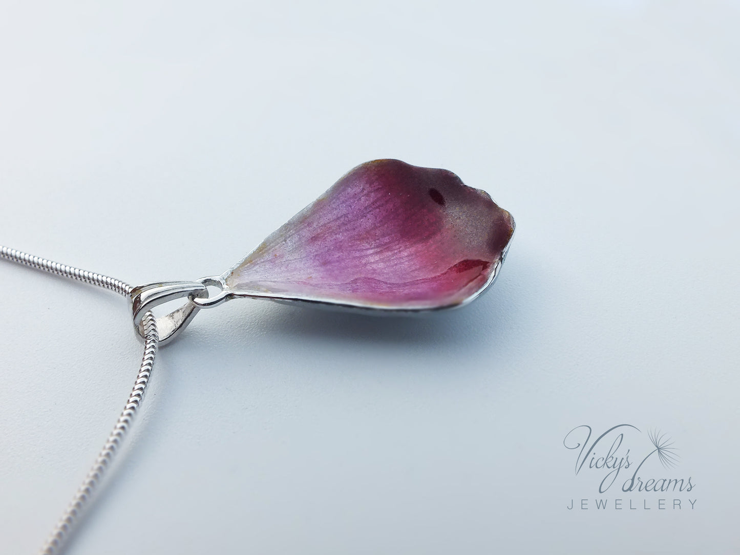 Pink flower petal pendant worn on sterling silver necklace