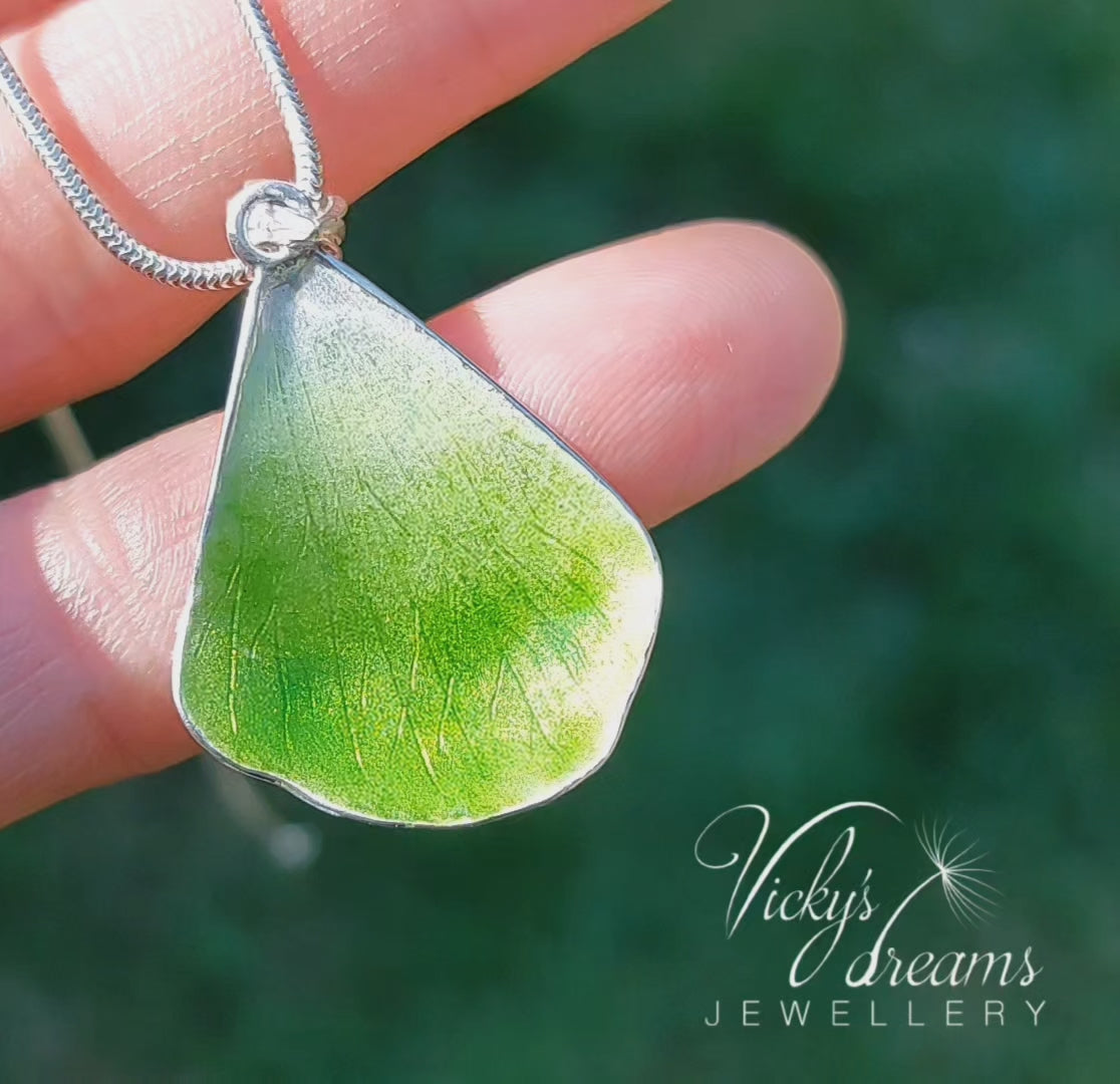 Green flower petal pendant worn on sterling silver necklace