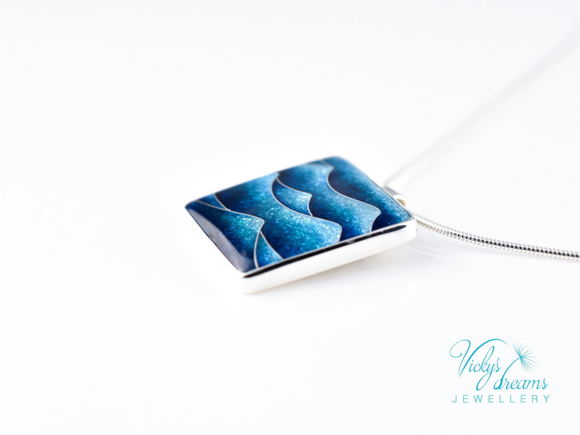 Bright blue cloisonné enamel necklace featuring ocean waves, set in sterling silver