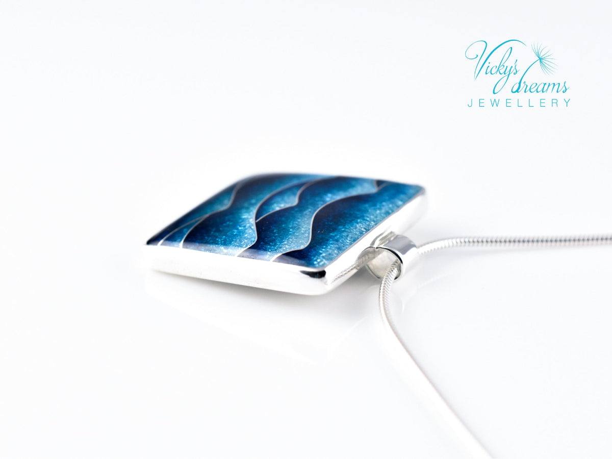 Bright blue cloisonné enamel necklace featuring ocean waves, set in sterling silver