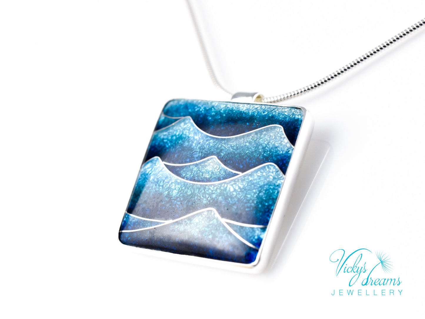 Bright blue cloisonné enamel necklace featuring ocean waves, set in sterling silver