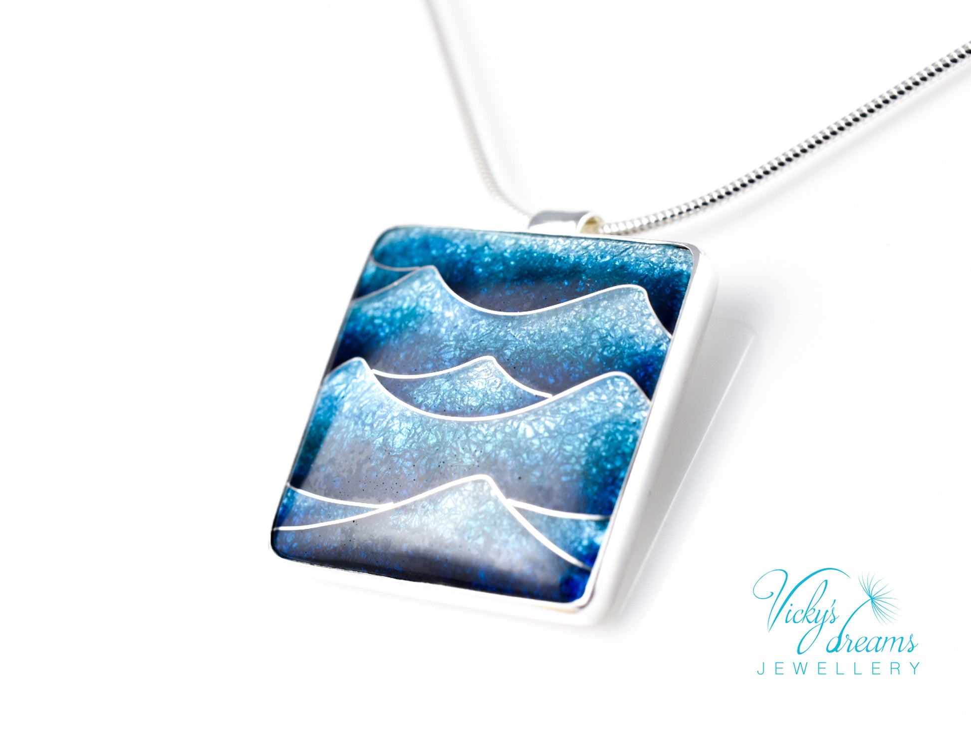 Bright blue cloisonné enamel necklace featuring ocean waves, set in sterling silver