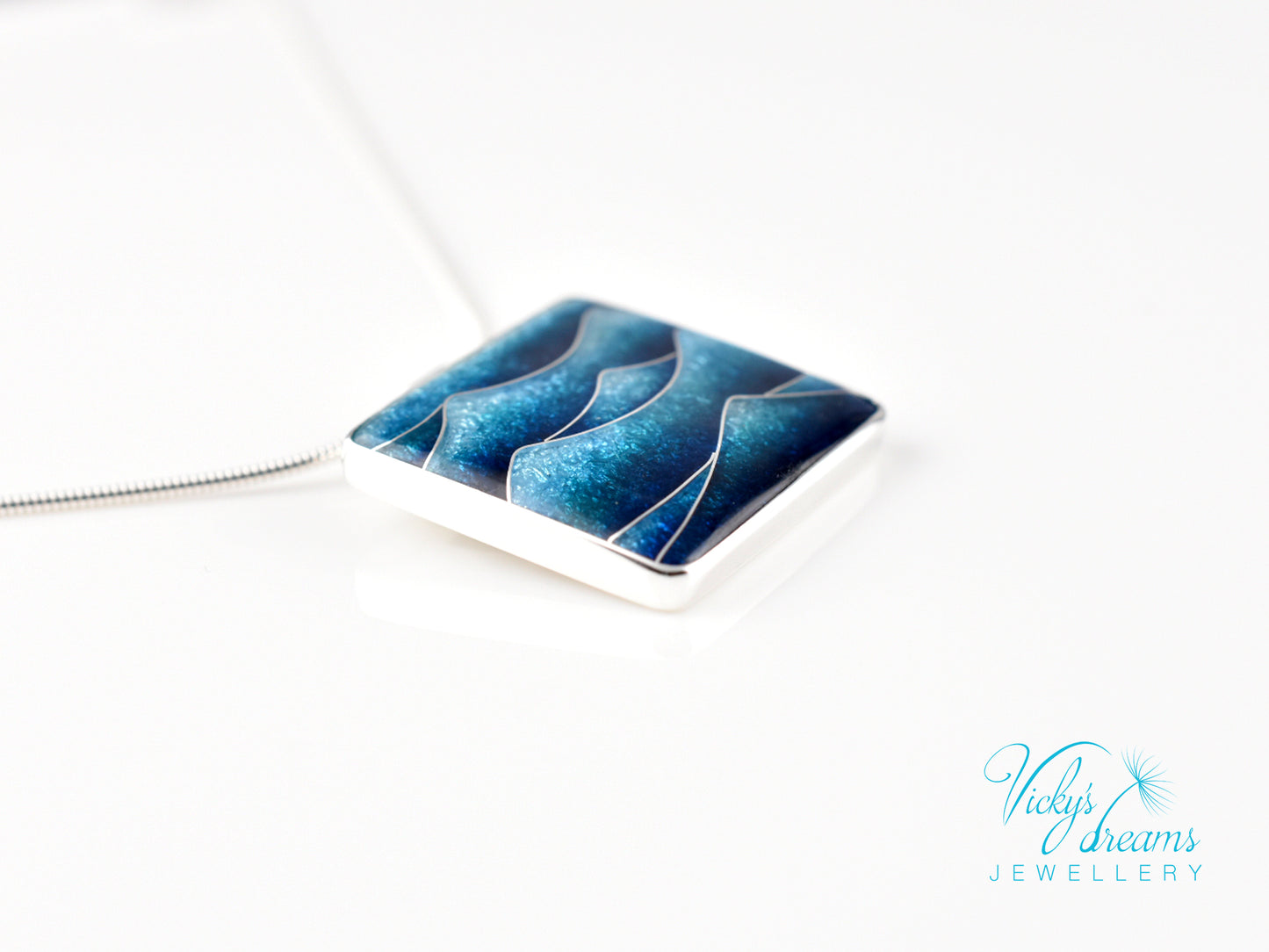 Bright blue cloisonné enamel necklace featuring ocean waves, set in sterling silver