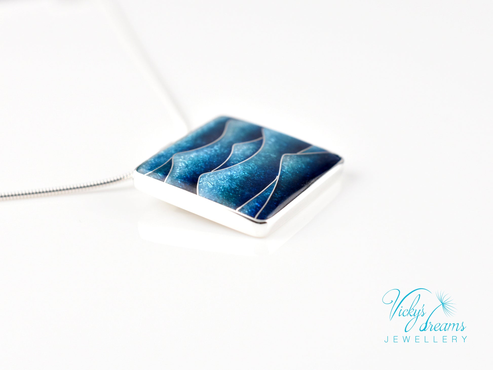 Bright blue cloisonné enamel necklace featuring ocean waves, set in sterling silver