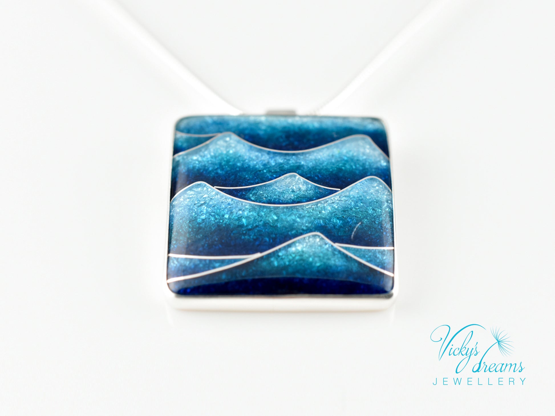 Bright blue cloisonné enamel necklace featuring ocean waves, set in sterling silver