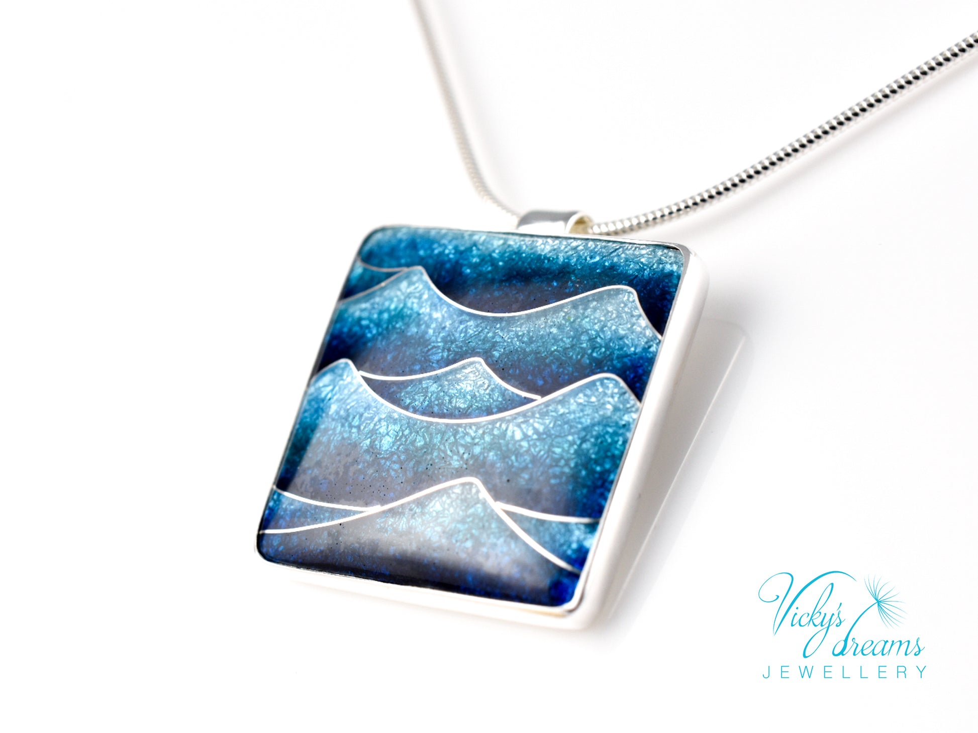 Bright blue cloisonné enamel necklace featuring ocean waves, set in sterling silver