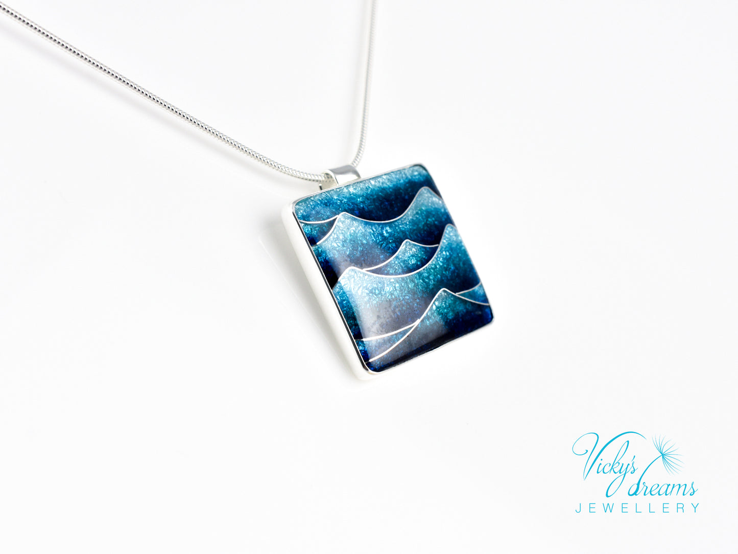 Bright blue cloisonné enamel necklace featuring ocean waves, set in sterling silver