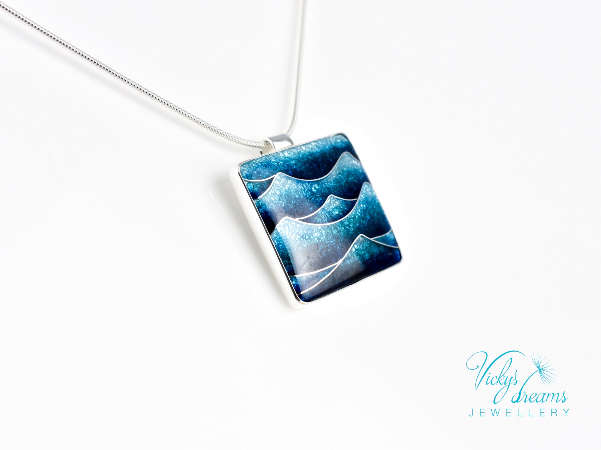 Bright blue cloisonné enamel necklace featuring ocean waves, set in sterling silver