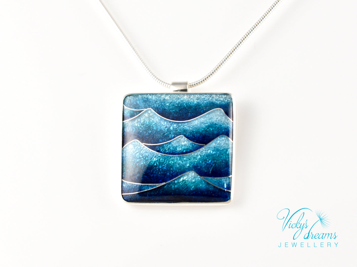 Bright blue cloisonné enamel necklace featuring ocean waves, set in sterling silver