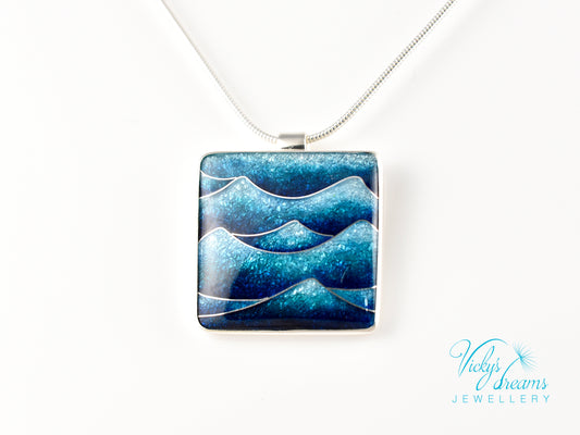 Bright blue cloisonné enamel necklace featuring ocean waves, set in sterling silver