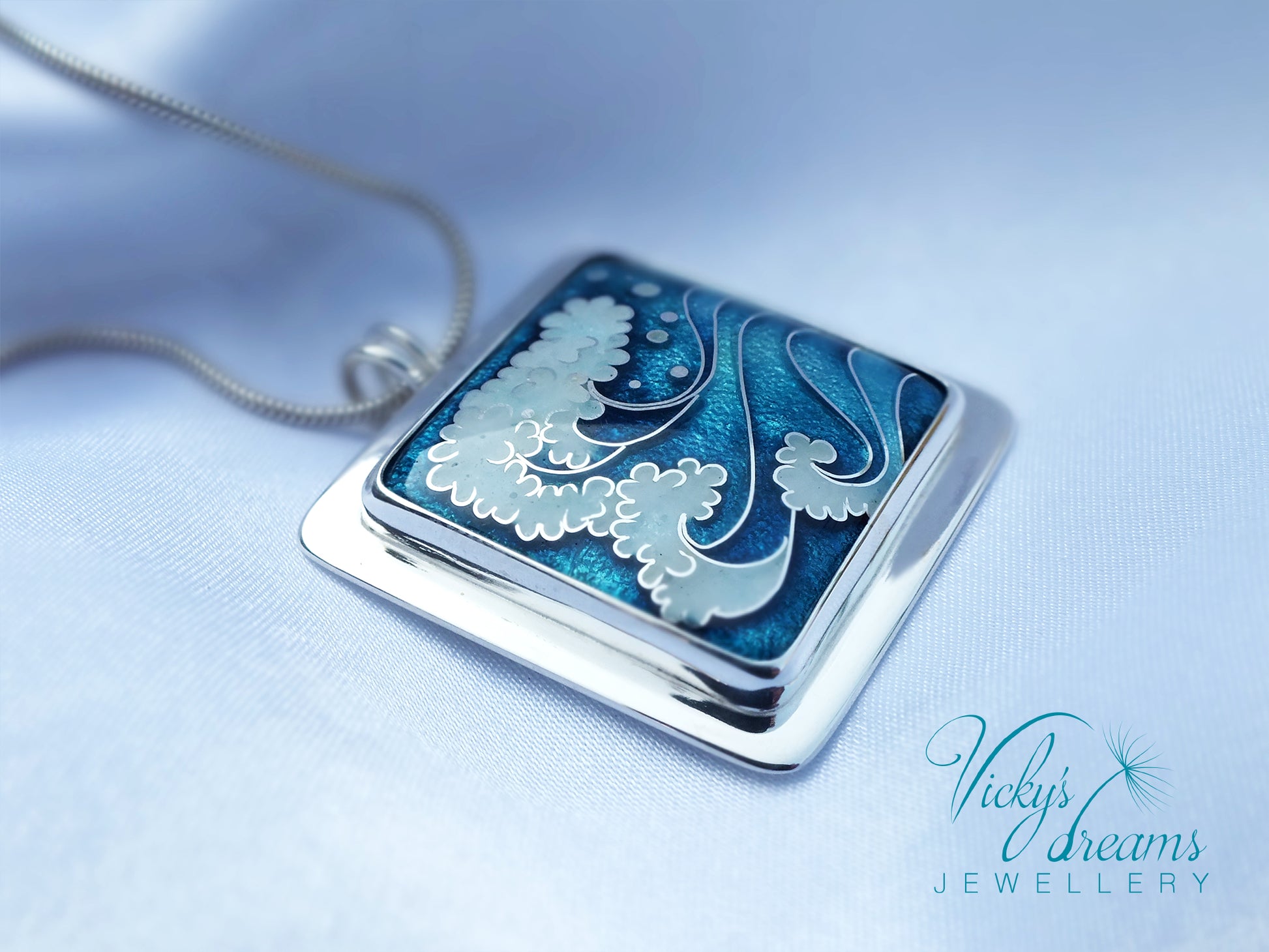 Jewelry pendant with blue and silver design on a light blue background, featuring 'Vicky's Dreams Jewellery' logo.