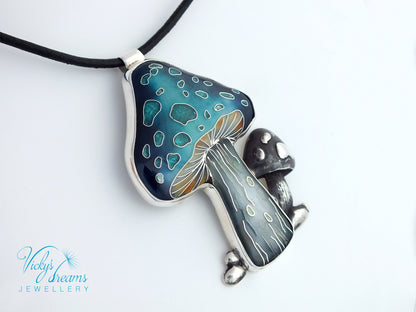 Mushroom-shaped pendant with blue and silver design on a white background