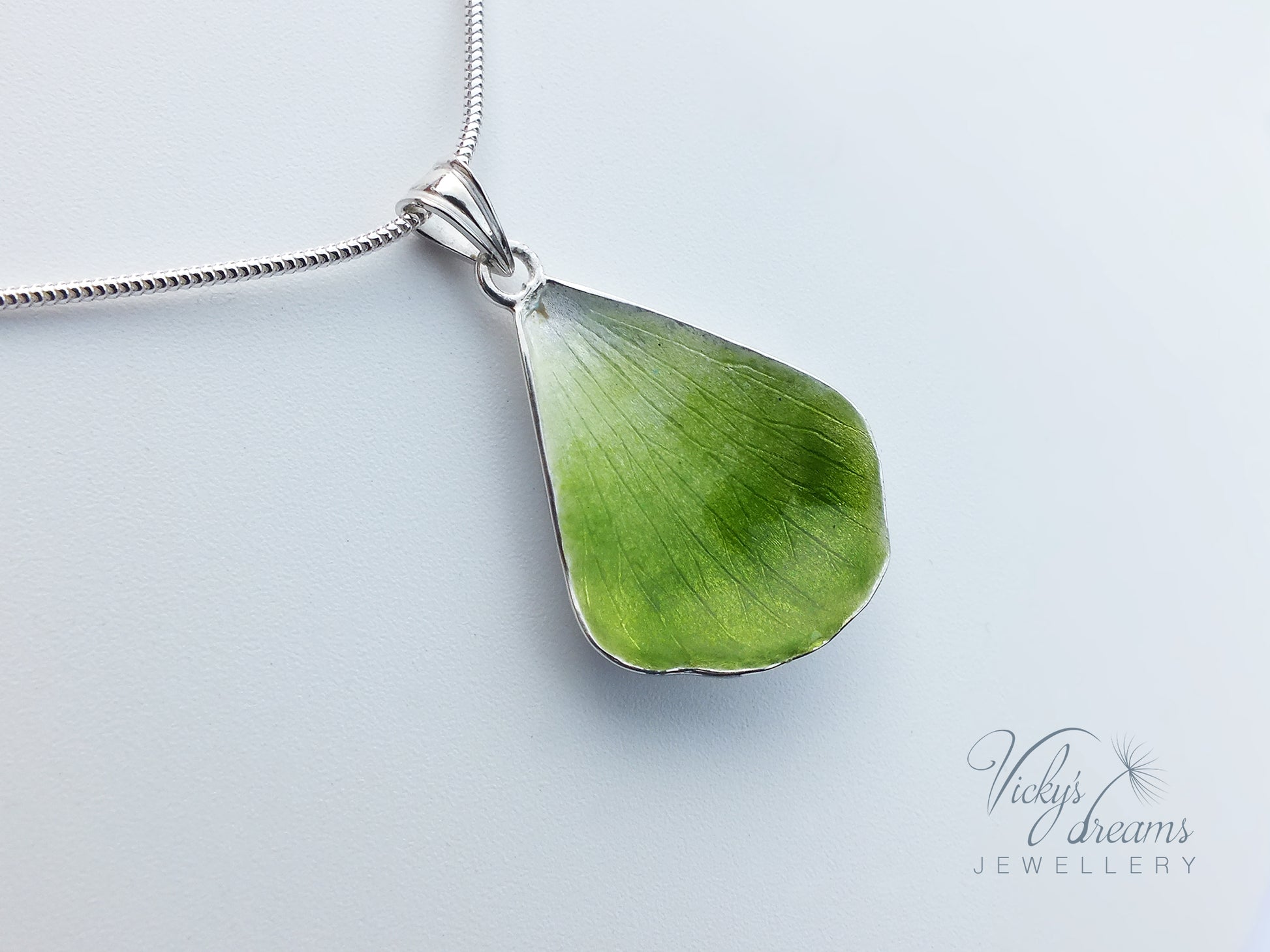 Green flower petal pendant worn on sterling silver necklace