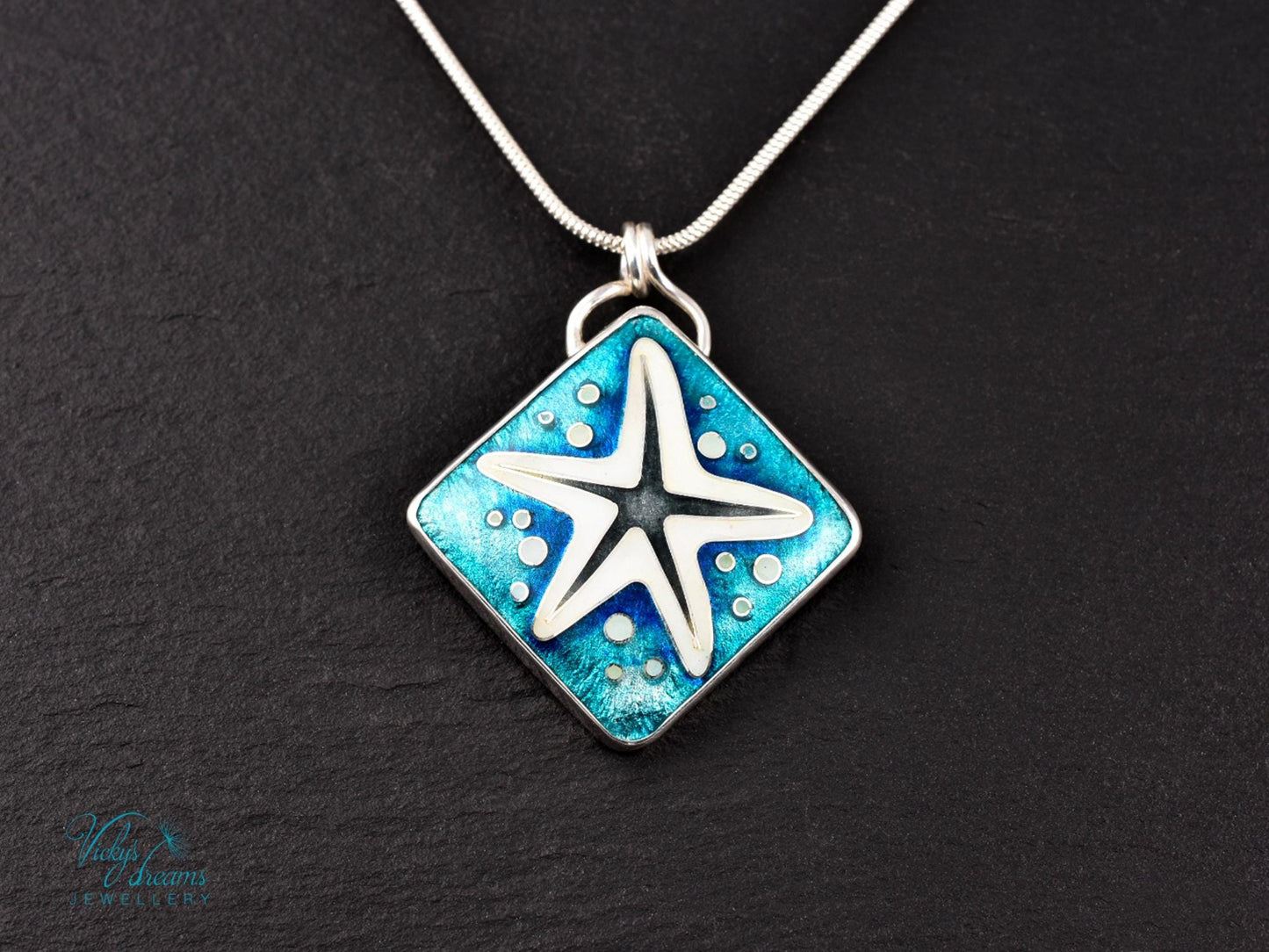 Handmade cloisonné enamel starfish pendant in ocean blue and ivory, set in sterling silver