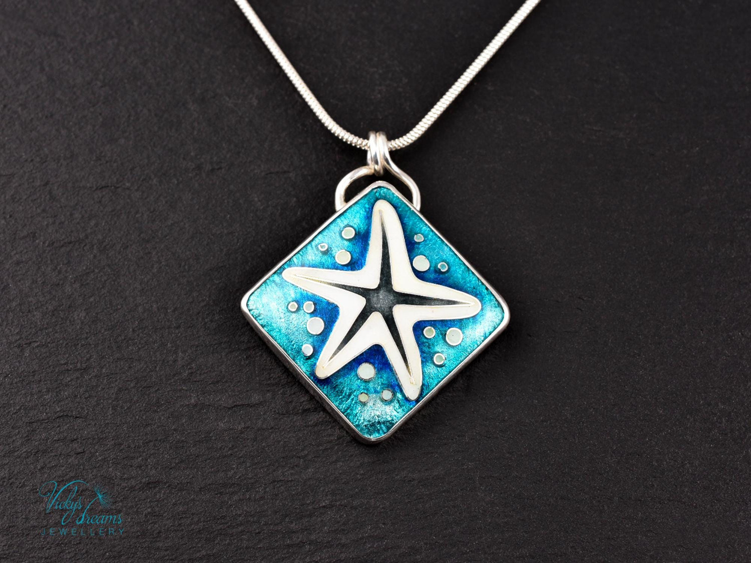 Handmade cloisonné enamel starfish pendant in ocean blue and ivory, set in sterling silver