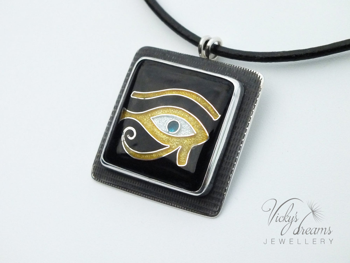 Handmade Egyptian cloisonné enamel Horus Eye pendant in black, gold, and blue set in oxidised sterling silver