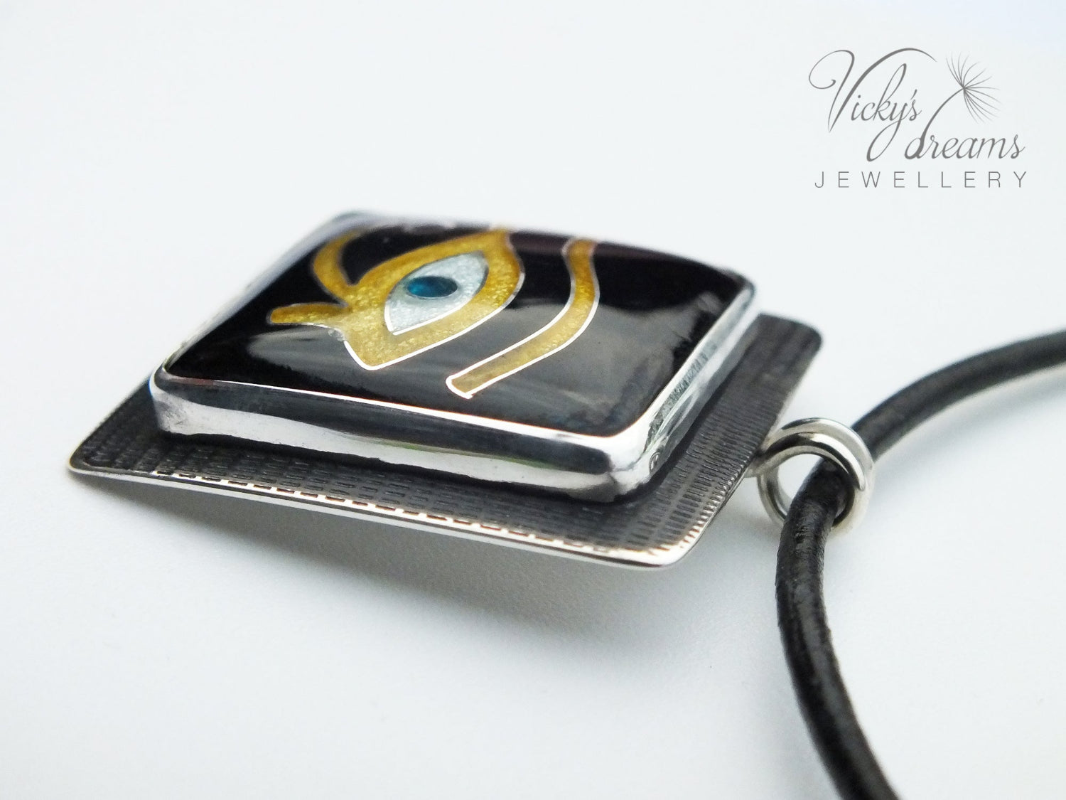 Handmade Egyptian cloisonné enamel Horus Eye pendant in black, gold, and blue set in oxidised sterling silver