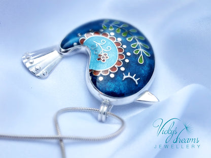 Decorative pendant with floral design on a blue background, featuring 'Vicky's Dreams Jewellery' logo.