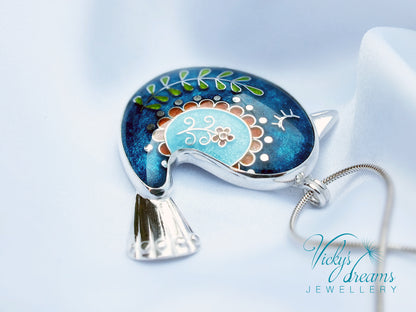 Decorative pendant with floral design on a blue background, featuring 'Vicky's Dreams Jewellery' logo.
