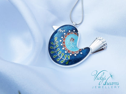 Decorative pendant with floral design on a light blue background, featuring 'Vicky's Dreams Jewellery' logo.