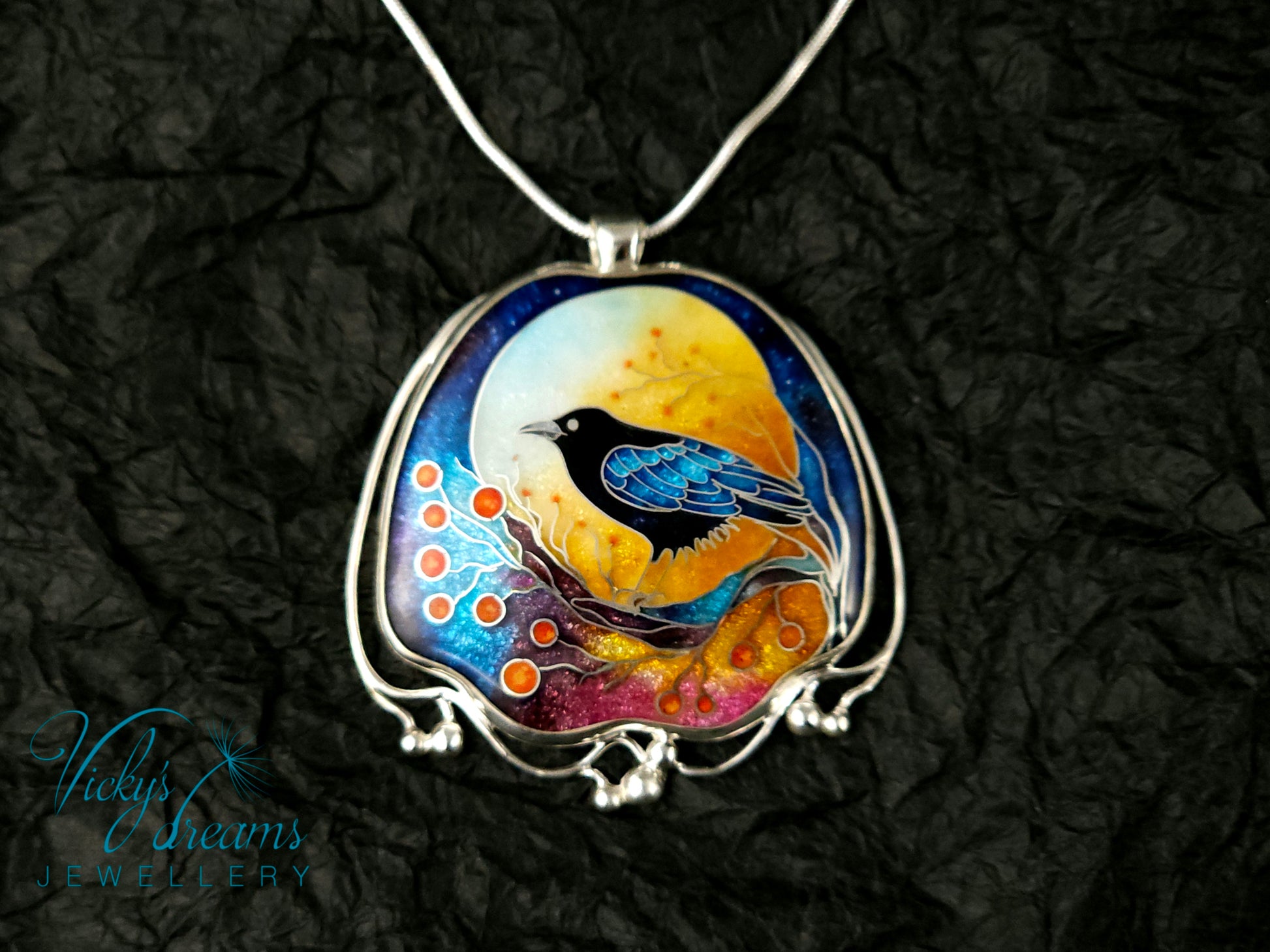 Handmade sterling silver cloisonné enamel pendant featuring a raven with red berries, vibrant blues and golden tones, nature-inspired jewellery