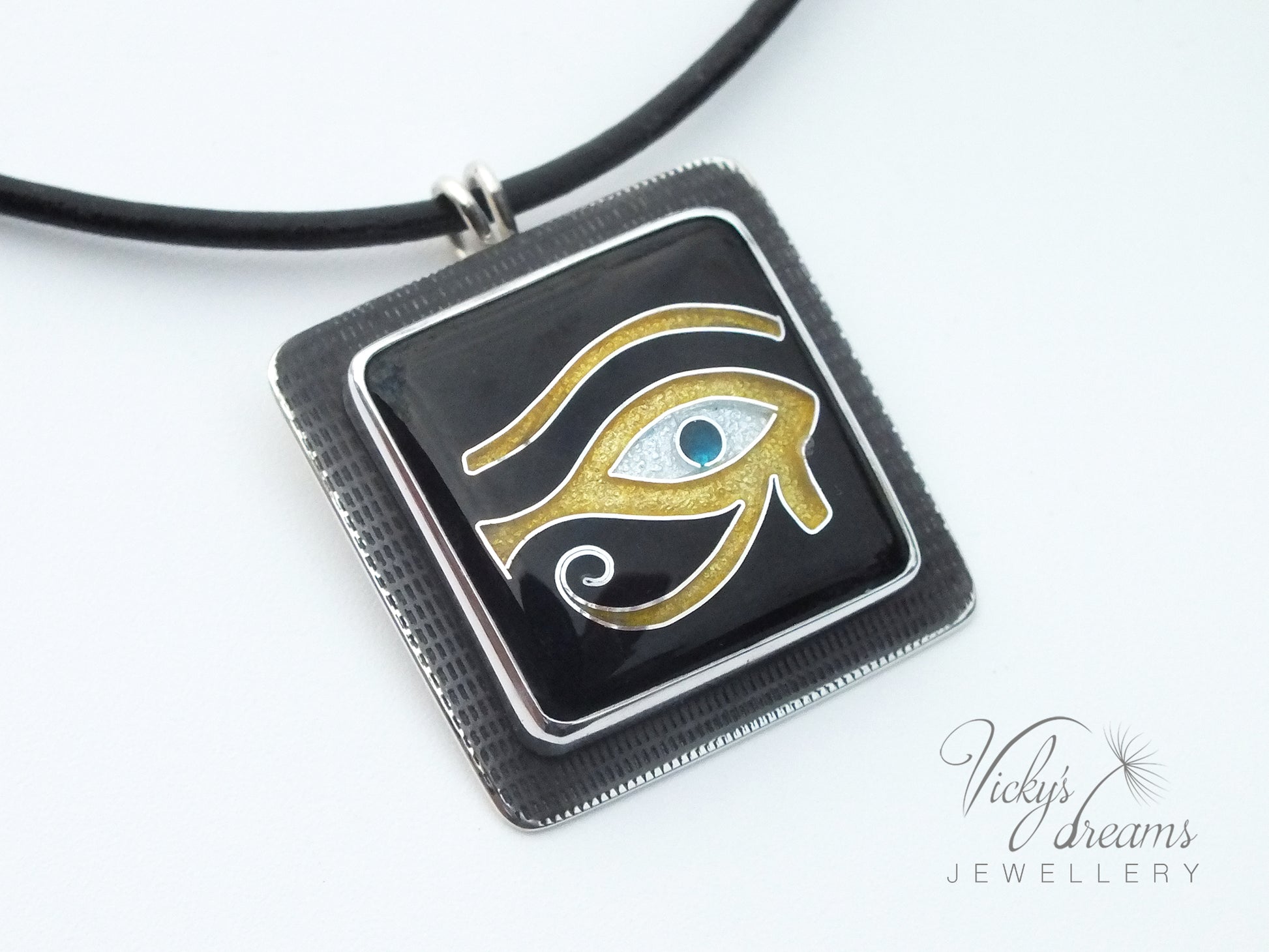 Handmade Egyptian cloisonné enamel Horus Eye pendant in black, gold, and blue set in oxidised sterling silver