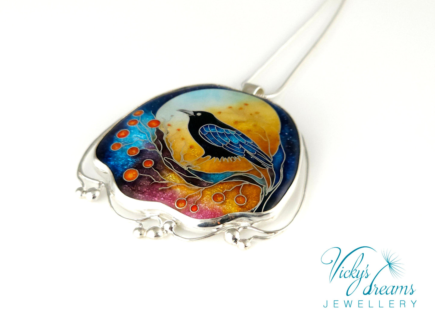 Handmade sterling silver cloisonné enamel pendant featuring a raven with red berries, vibrant blues and golden tones, nature-inspired jewellery