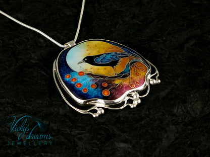 Handmade sterling silver cloisonné enamel pendant featuring a raven with red berries, vibrant blues and golden tones, nature-inspired jewellery
